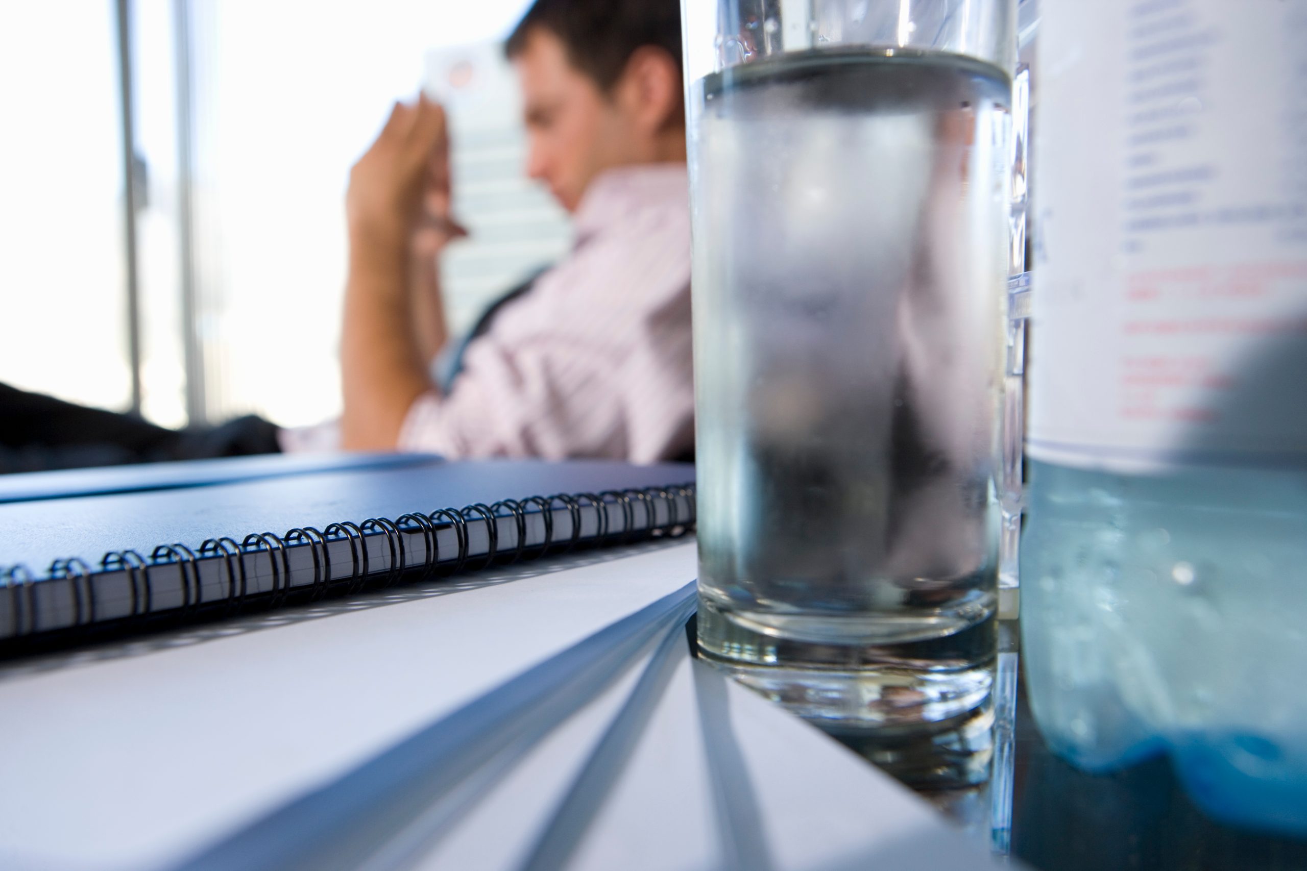 glass-of-water-by-paperwork-on-desk-of-young-busin-2025-10-14-05-10-11-utc